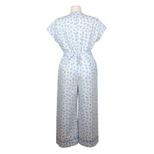 Upcycling summer overall for women with short sleeves. V neck, loose fit with belt at the waist, pants length above the ankle. Upcycled white cotton fabric with small blue flowers pattern