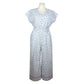 Upcycling summer overall for women with short sleeves. V neck, loose fit with belt at the waist, pants length above the ankle. Upcycled white cotton fabric with small blue flowers pattern