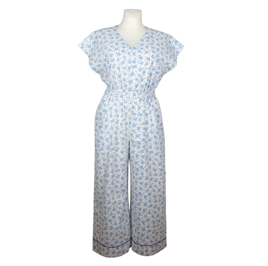 Upcycling summer overall for women with short sleeves. V neck, loose fit with belt at the waist, pants length above the ankle. Upcycled white cotton fabric with small blue flowers pattern