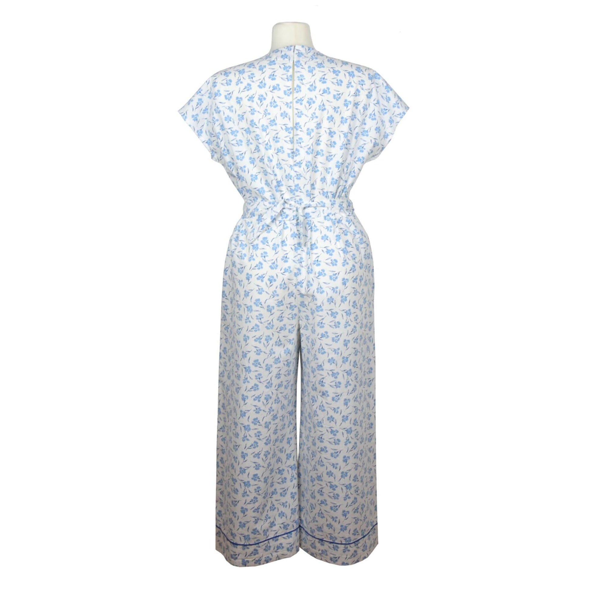 Upcycling summer overall for women with short sleeves. V neck, loose fit with belt at the waist, pants length above the ankle. Upcycled white cotton fabric with small blue flowers pattern
